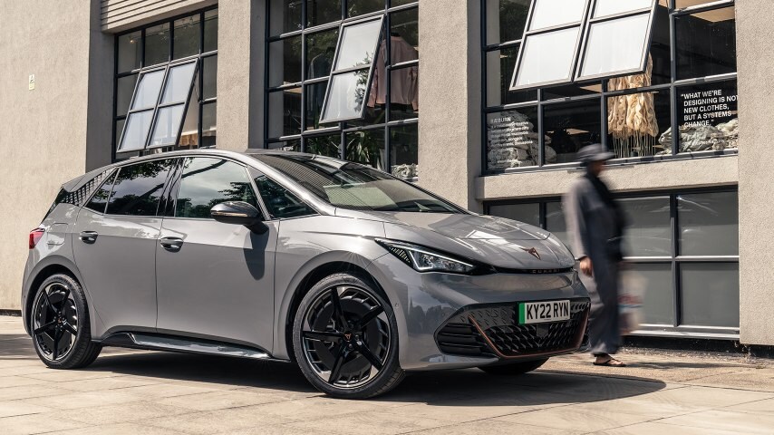 A CUPRA Born next to a building with the windows open