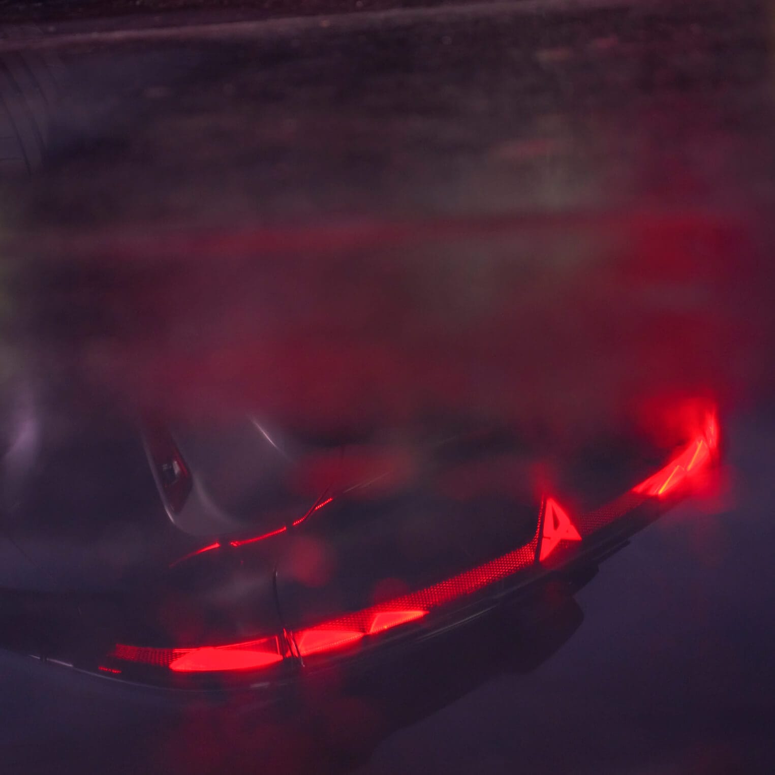 A reflection of the CUPRA Raval rear lights with the logo lit up