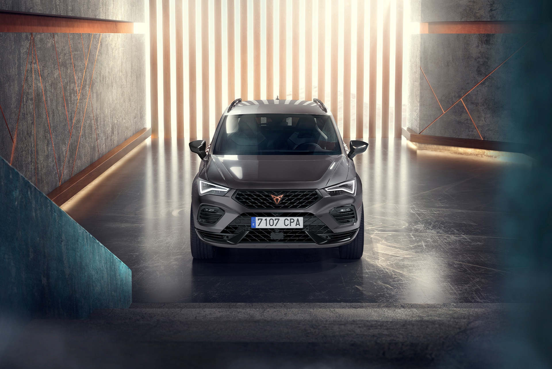 Front view of the CUPRA Ateca driving through water, showcasing its accentuated bonnet, full LED headlights, dark aluminium detailing and performance brakes with Brembo calipers.