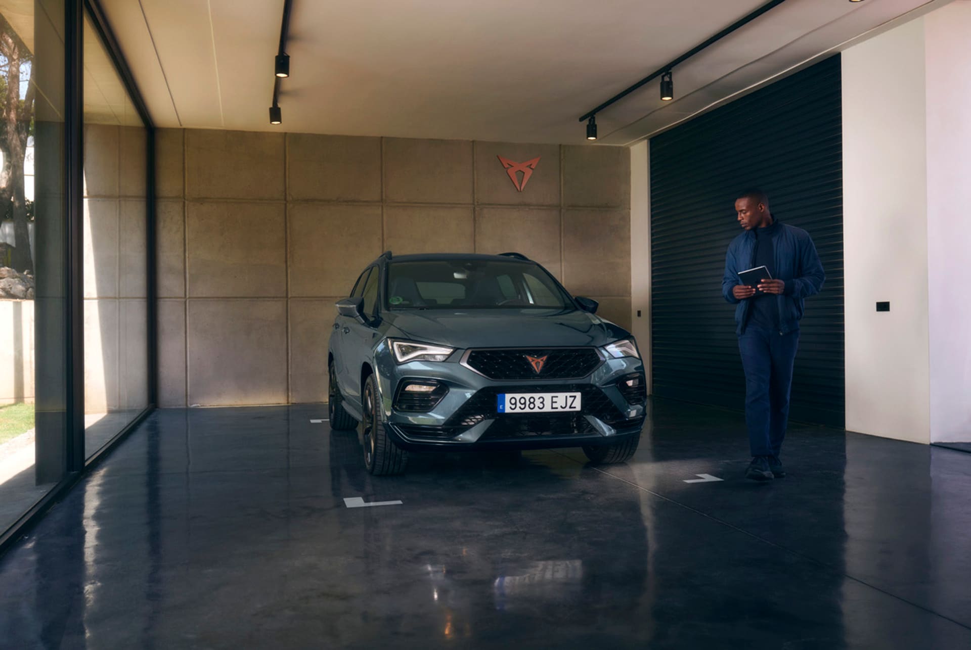 Front view of the CUPRA Ateca with a person standing beside it, holding a clipboard