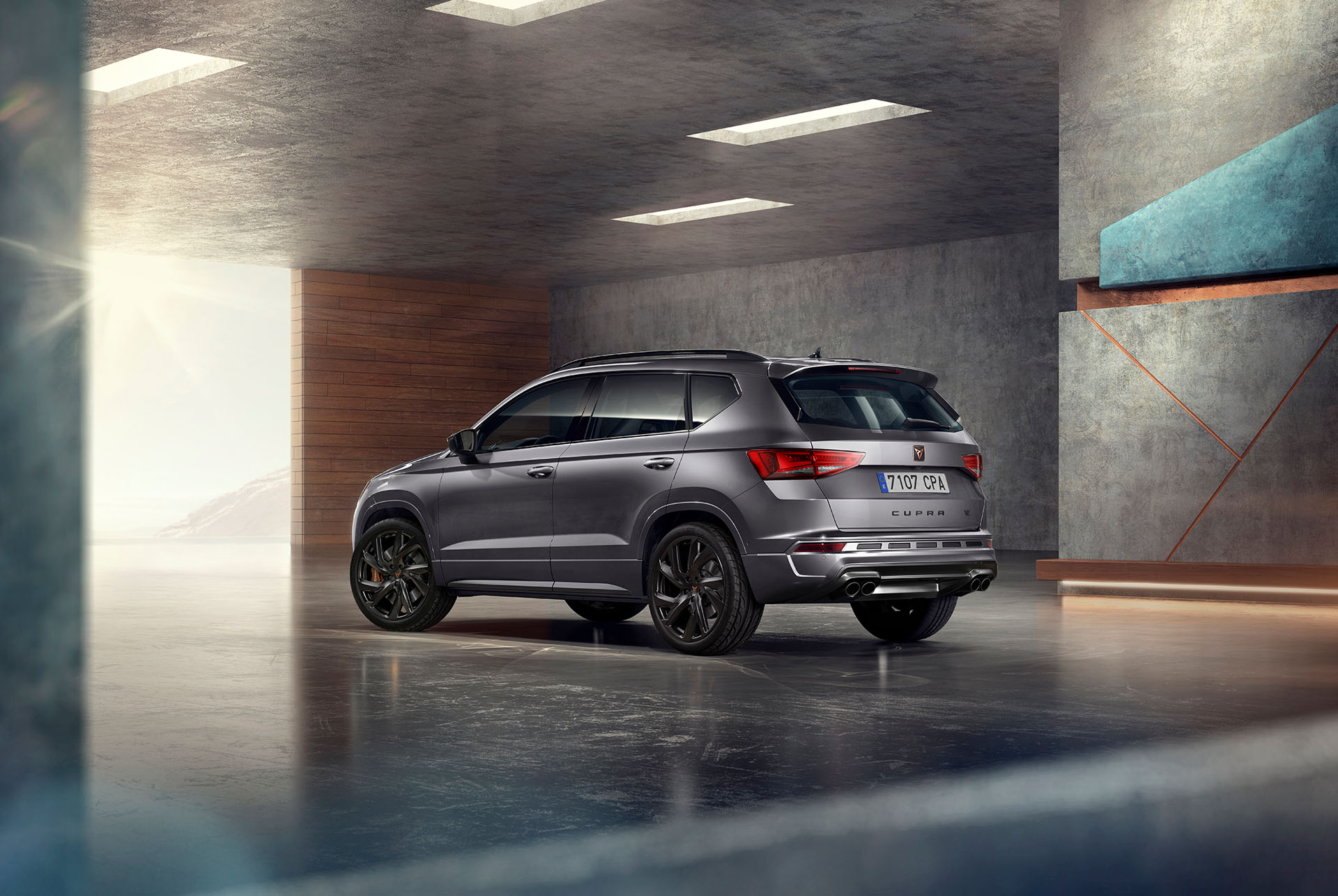 A grey cupra ateca suv displayed against a white background. The car features a bold front grille, led headlights and copper accent alloy wheels, highlighting its sporty car design.
