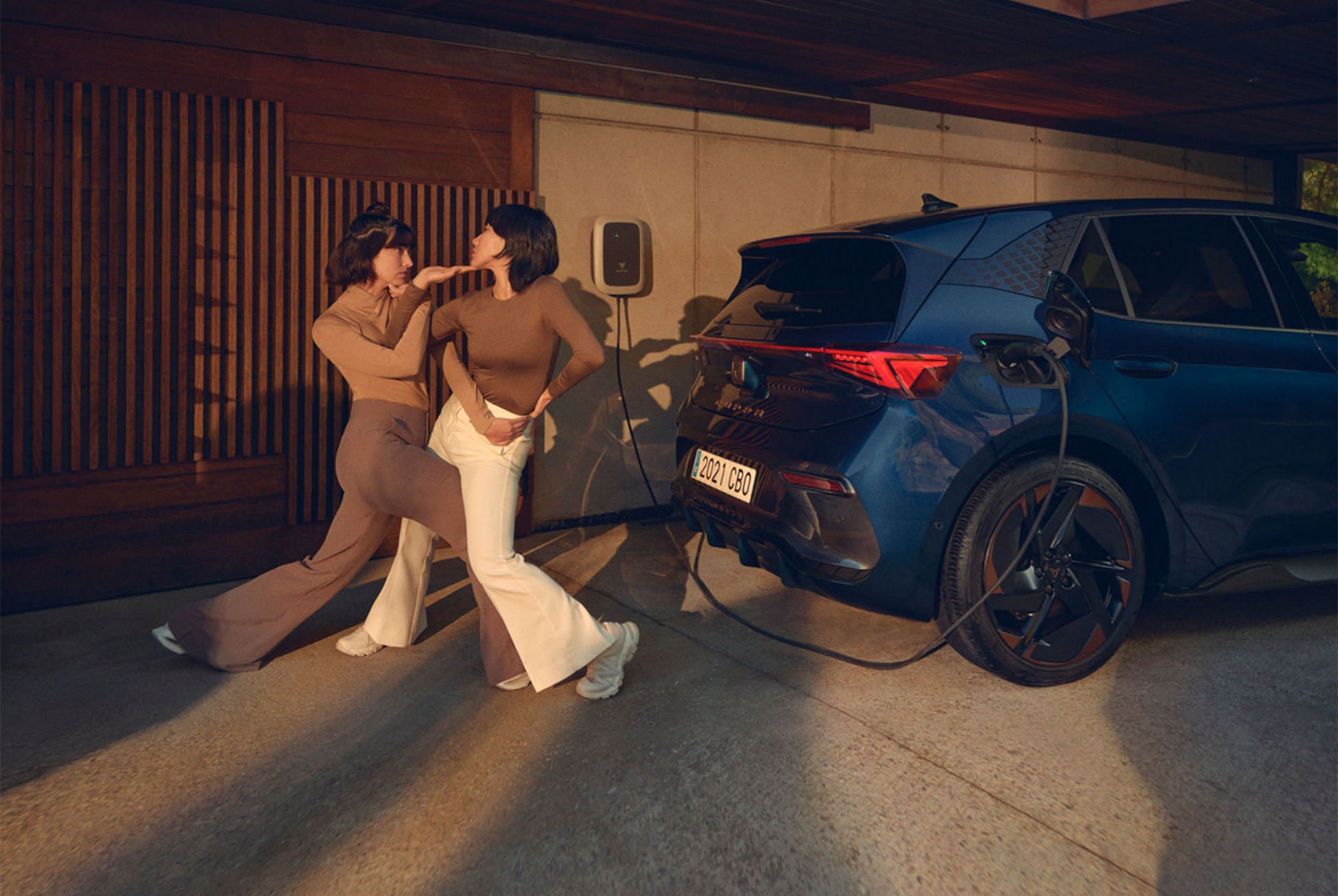 Women posing with CUPRA Born charging at home