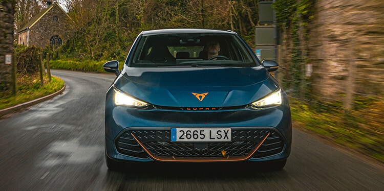 an Aurora Blue CUPRA Born driving through the countryside