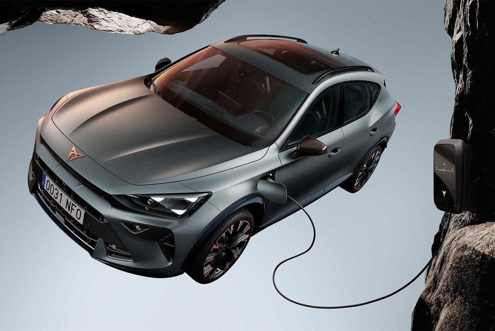 CUPRA Formentor charging and showcasing its design details, in a solid background and a rocky setting, with a spider and a spiderweb.