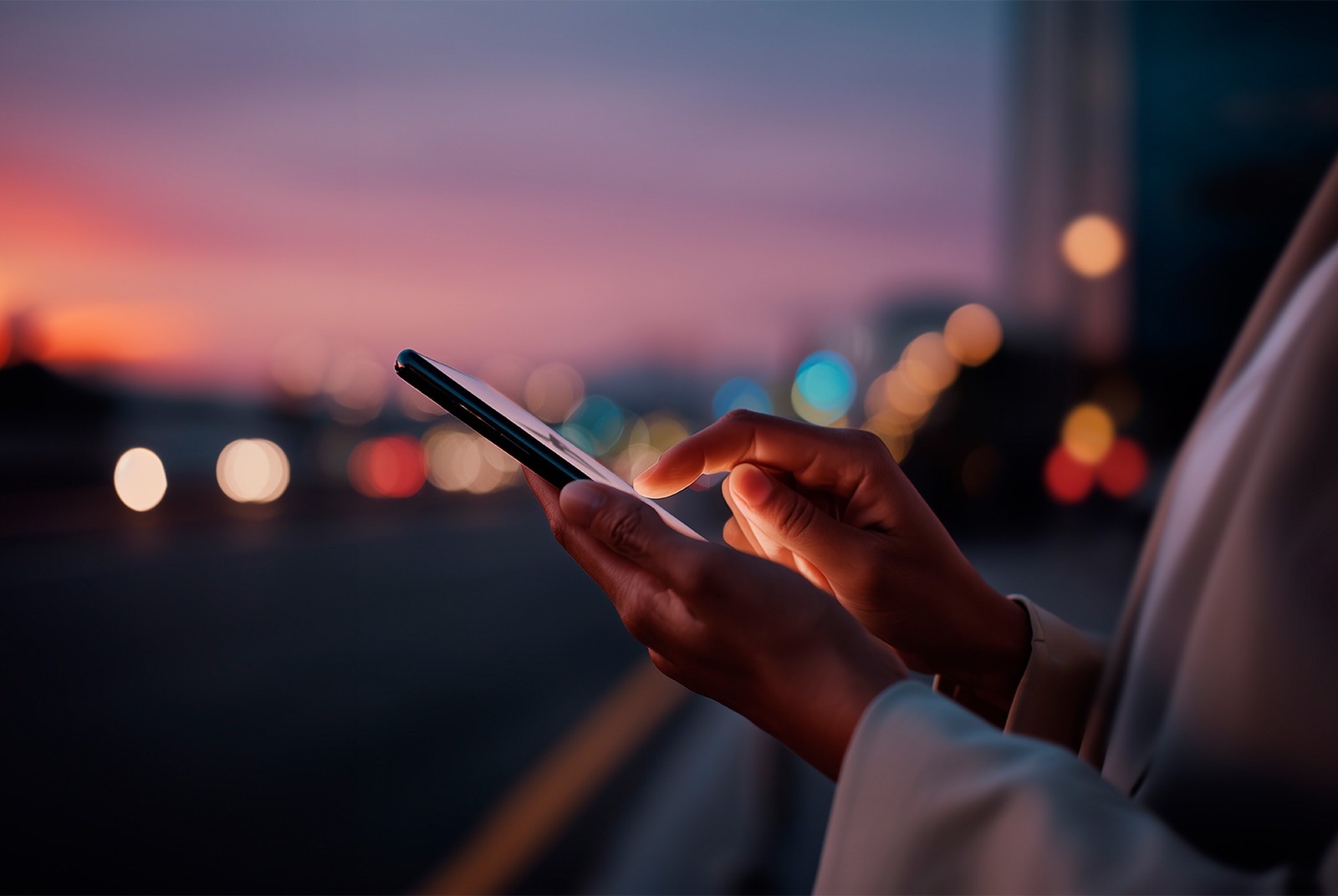 A person outdoors holds their smartphone, illustrating that you can seamlessly set up your car to suit your preferences from anywhere.
