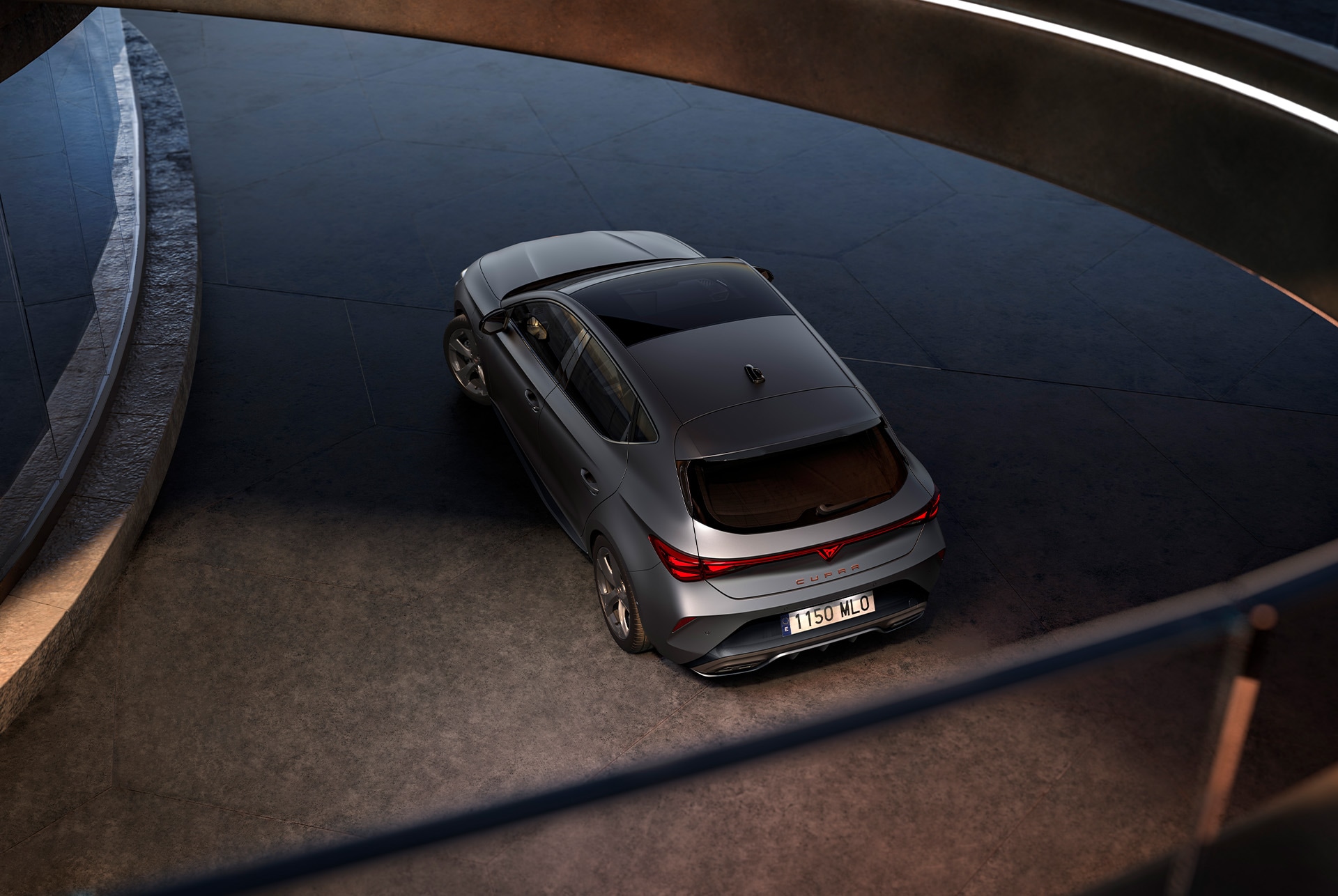: three quarter bird’s eye view of the new cupra leon 2024 rear, dark setting and mirror reflection of the front.