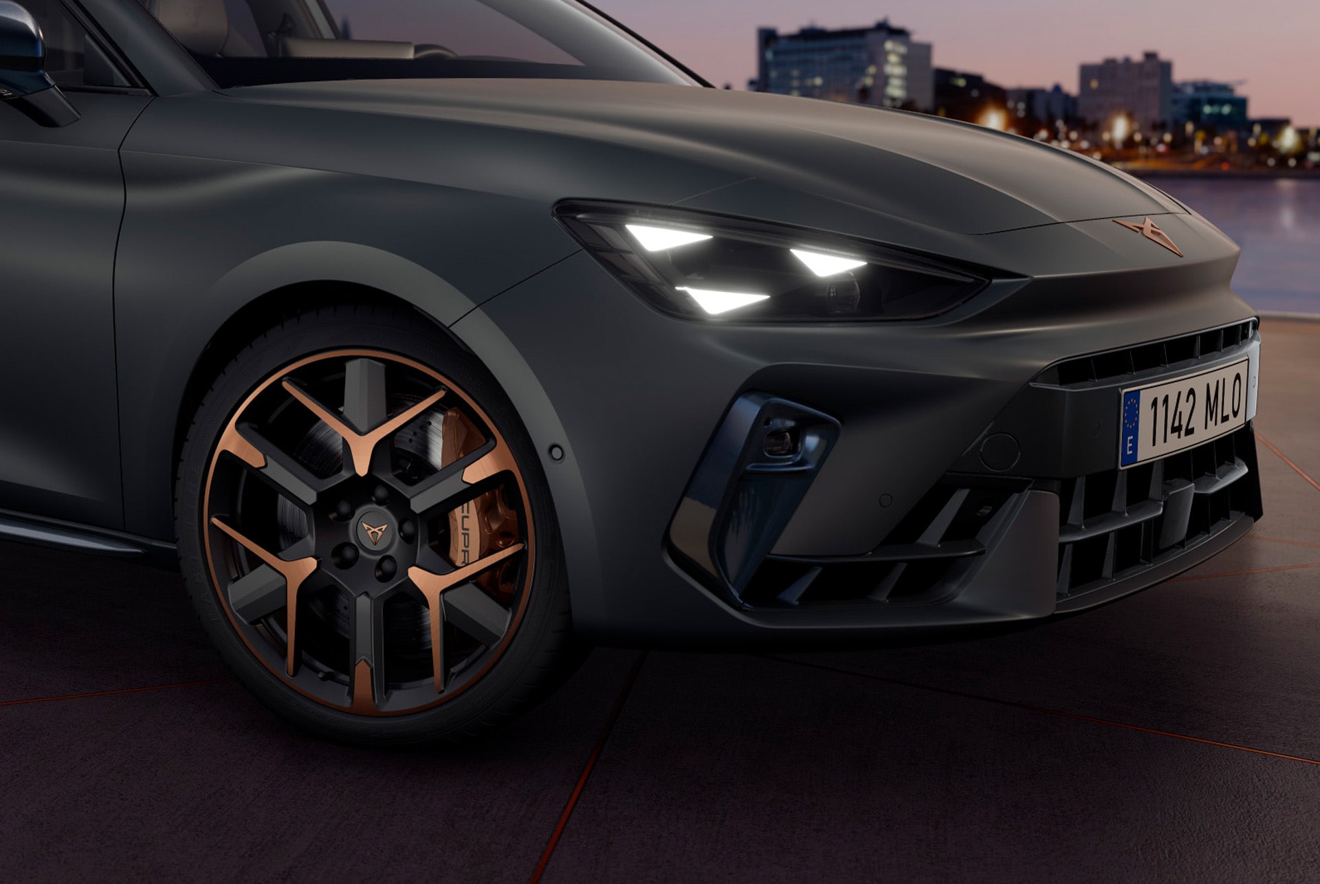 CUPRA Leon Estate 2025 close up of copper accent and black wheel and triangle eye cupra headlight, enceladus grey matt car body