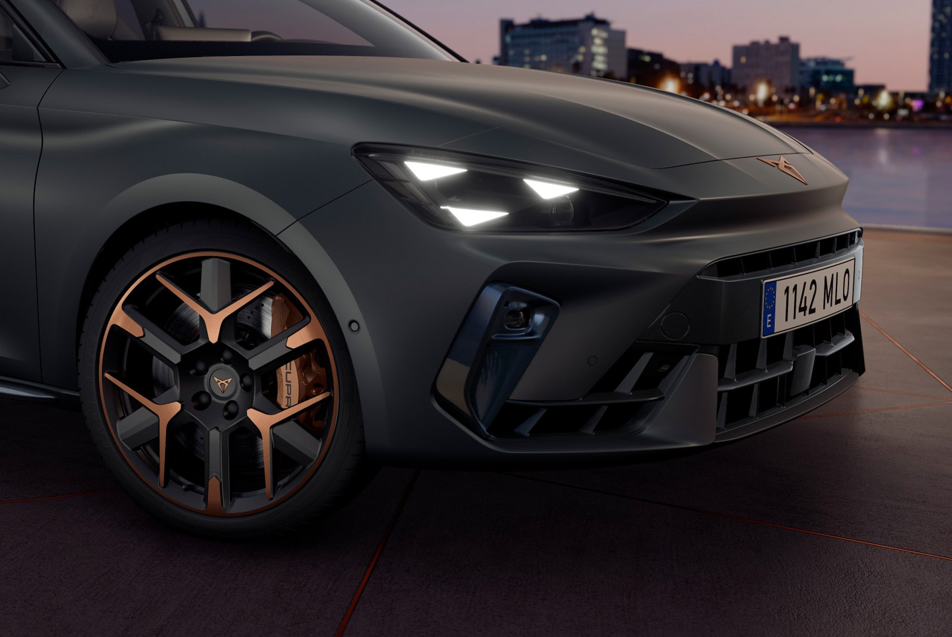 CUPRA Leon Estate 2025 hybrid car technology, parked on concrete, cityscape and architectural concrete structure with cupra matrix led headlights