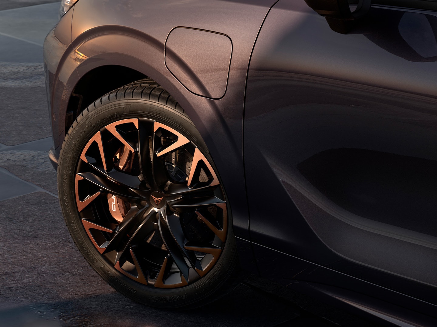 Side view of CUPRA Terramar with maximum braking power, parked by the coast, highlighting the dark void paint and its 20” Hadron Copper alloy wheels.