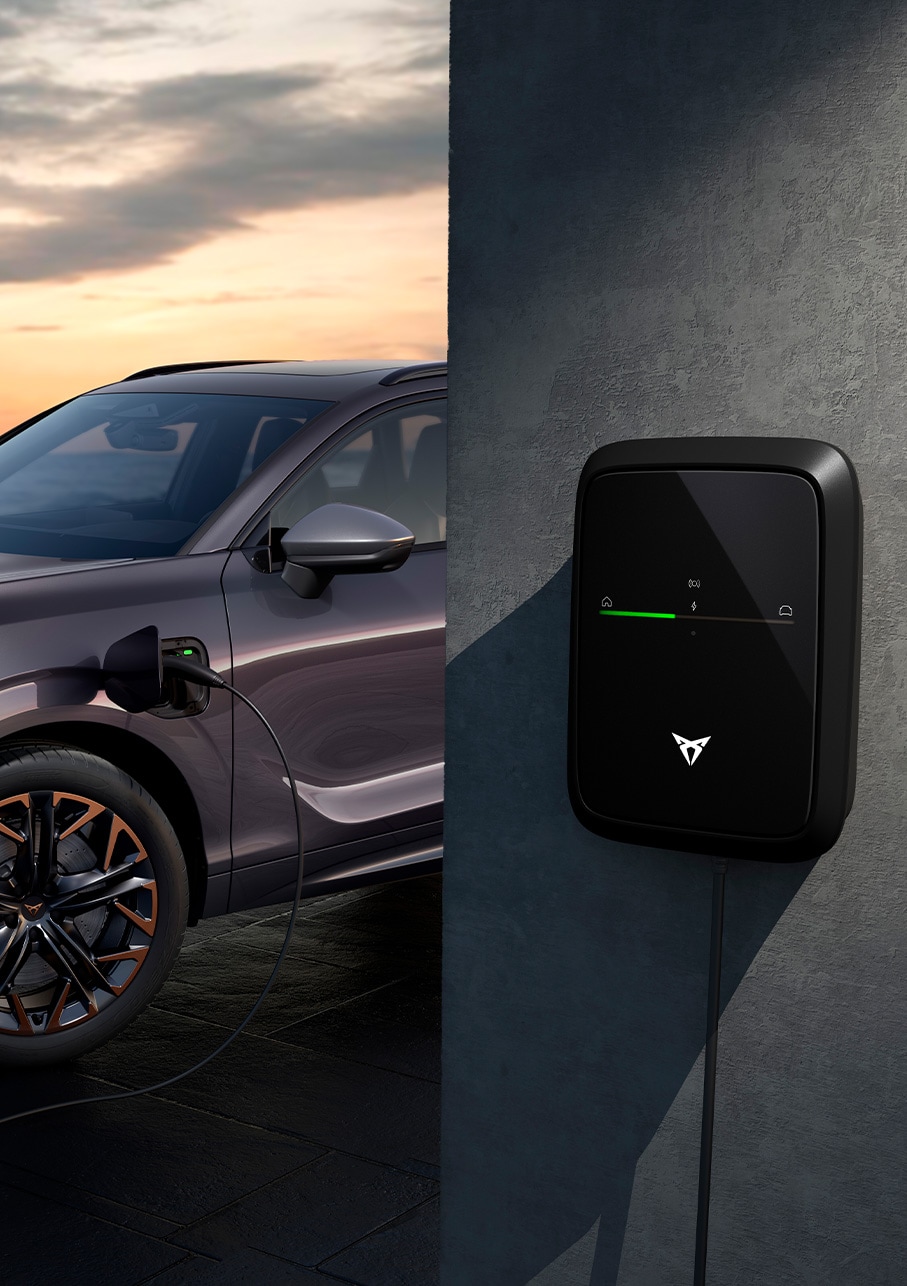 side view of the cupra terramar 2025 in the colour dark void, parked in an outdoors environment showcasing the car’s charging point.