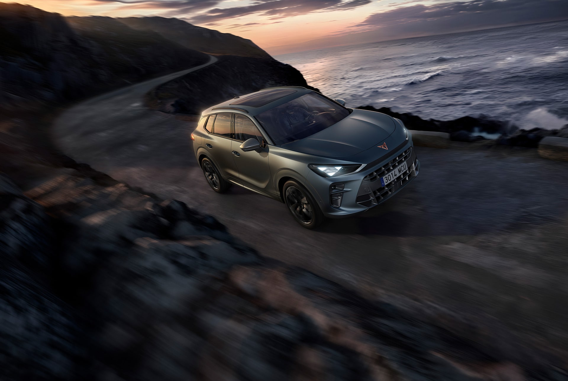 cupra terramar 2025, the best compact sport utility car, driving along a coastal road featuring dark void paint, 20” hadron copper alloys and high canyon leather seats.