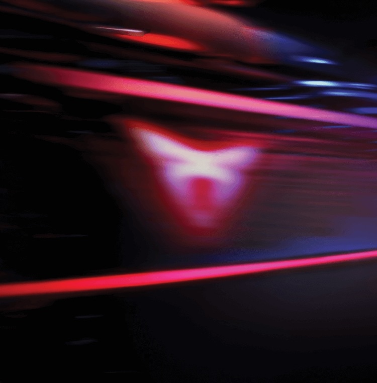 A blurred pink CUPRA logo against a background of wavey pink and blue neon lights