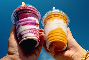 Two hand holding two smoothies