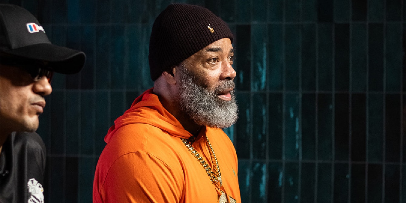 Two men sitting on a stage and talking to someone off-camera