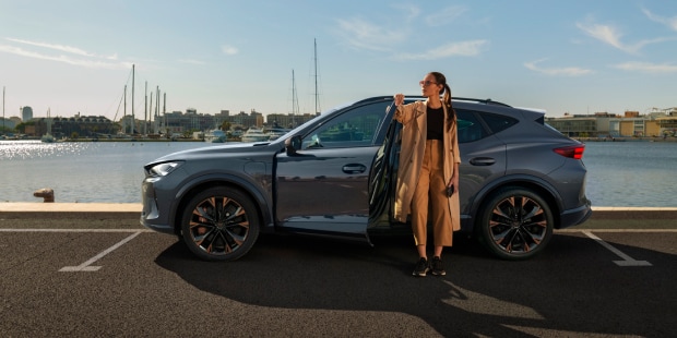 Woman standing next to a CUPRA Formentor in the sun