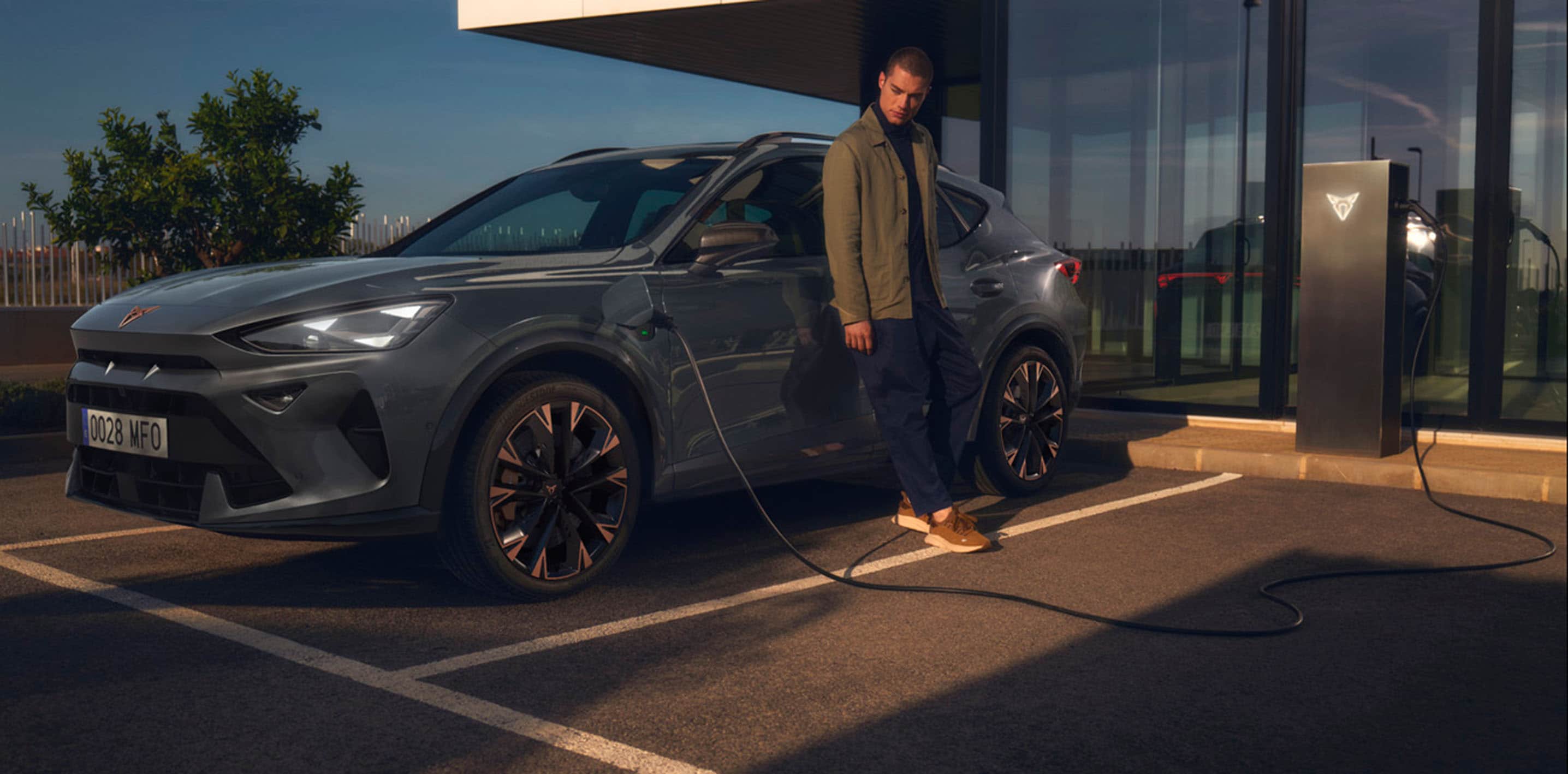 magnetic tech grey cupra formentor charging with man outside waiting