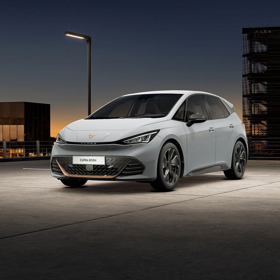 A CUPRA Born parked in a car park at night