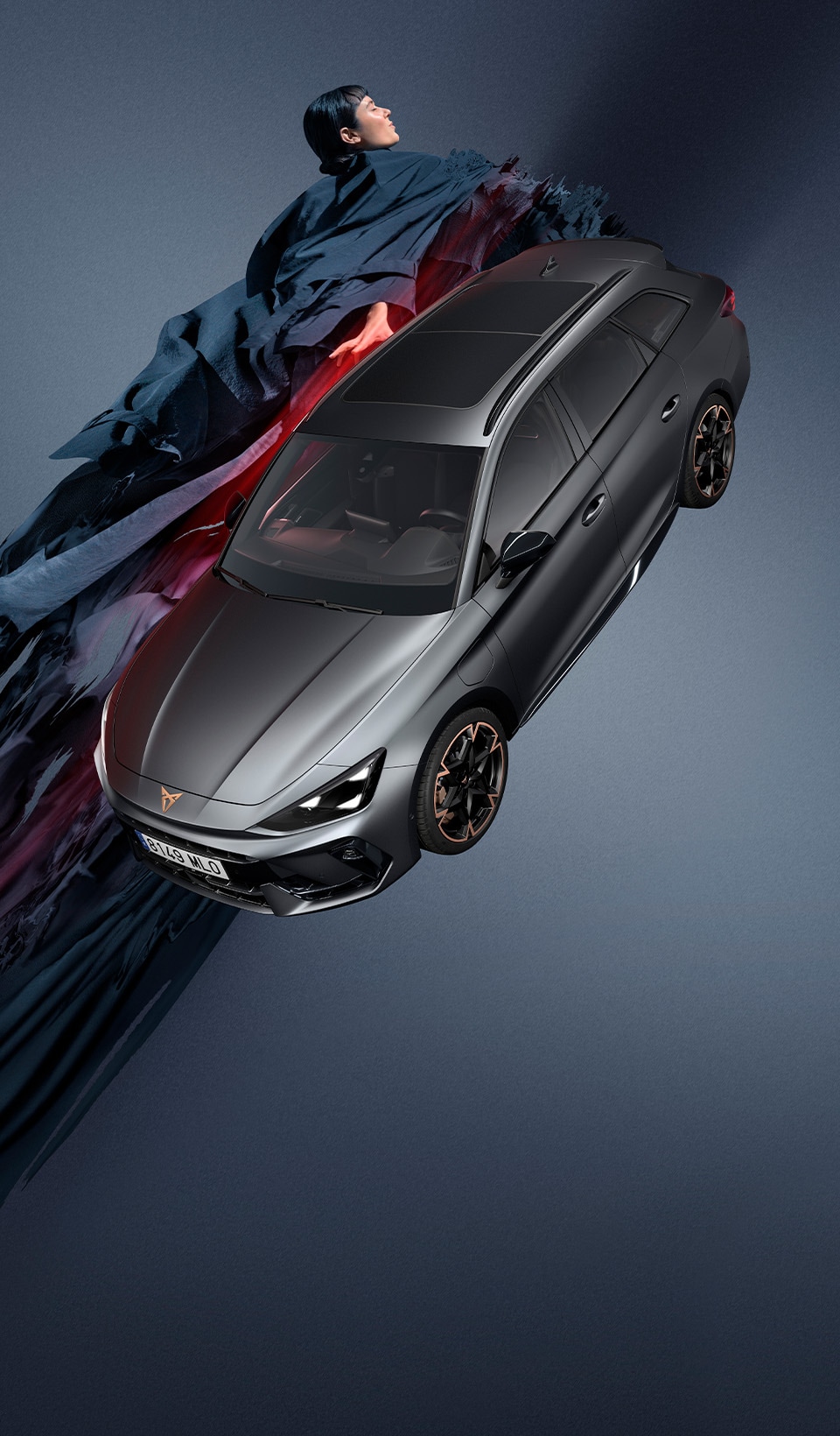 A CUPRA Leon Estate on a dark background with a person next to it