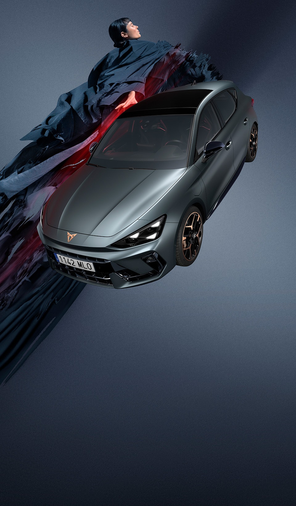 A CUPRA Leon on a dark background with a person next it