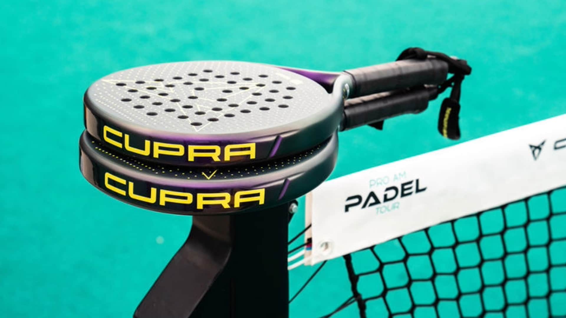 Two CUPRA branded padel rackets on a tennis court rail