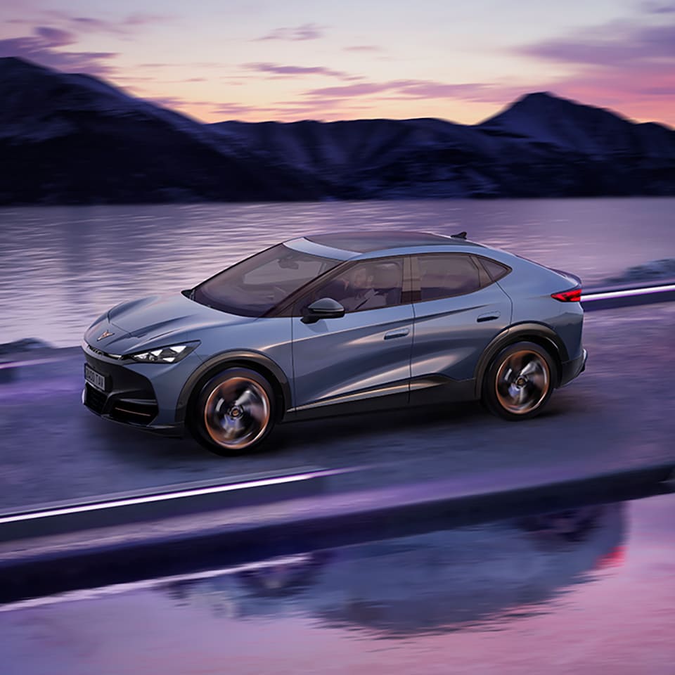 A CUPRA Tavascan being driven on road with water on either side