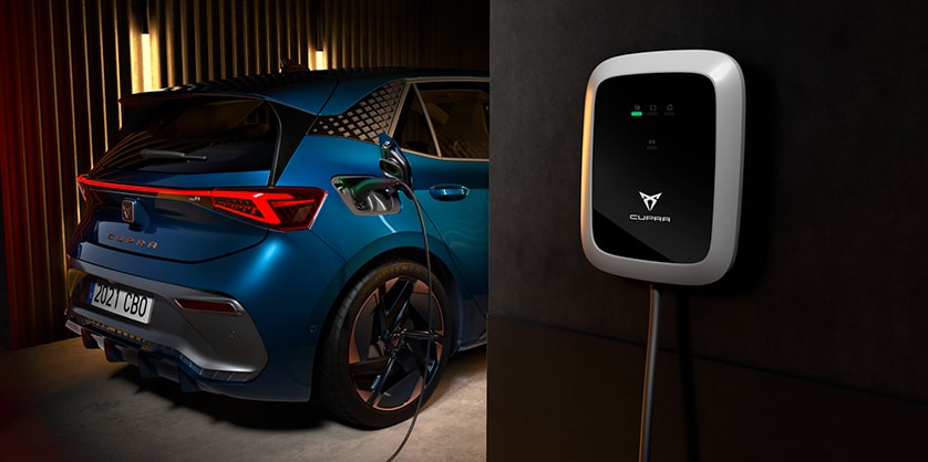 A CUPRA Born being charged from a wall box device