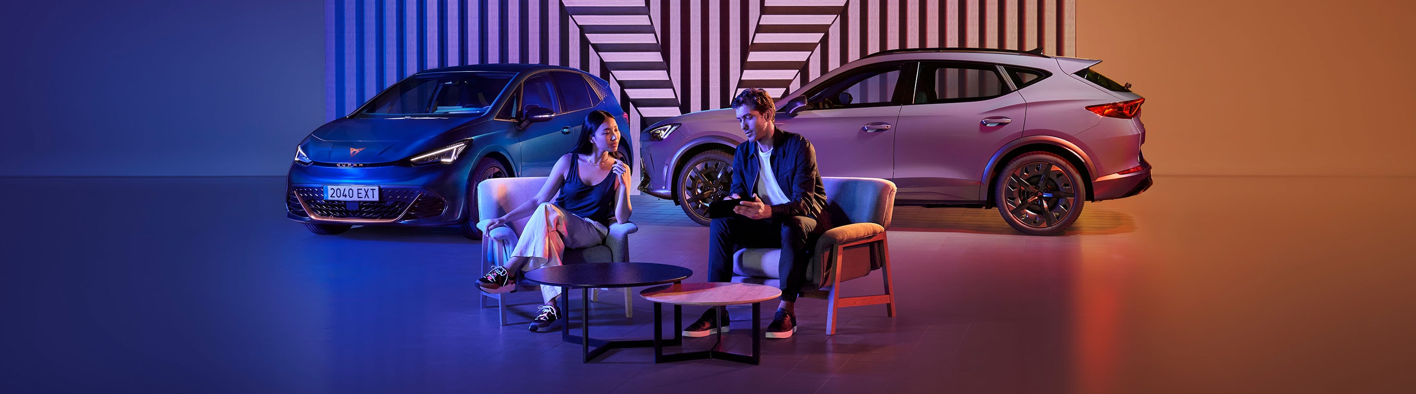 A man and woman sitting in front of a CUPRA Born and a CUPRA Ateca