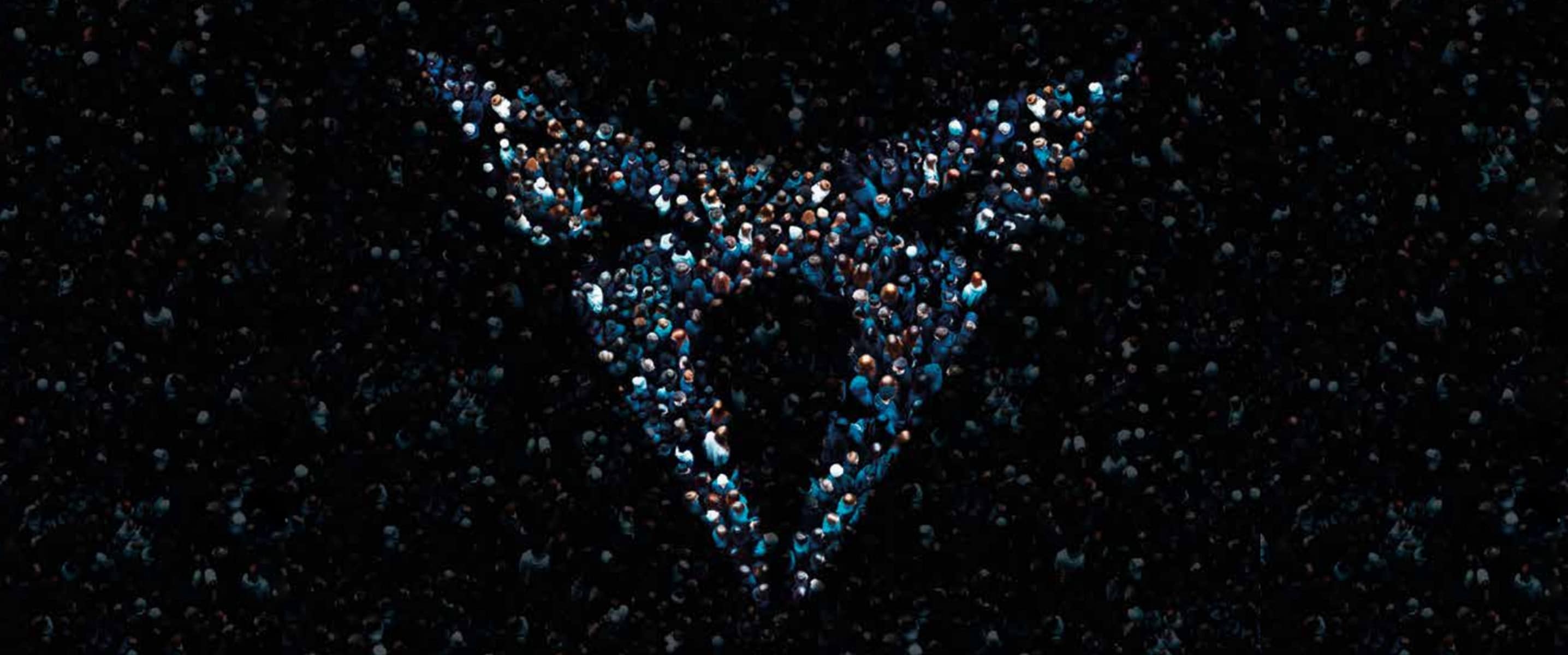 A crowd of people with the CUPRA logo shape illuminated over them