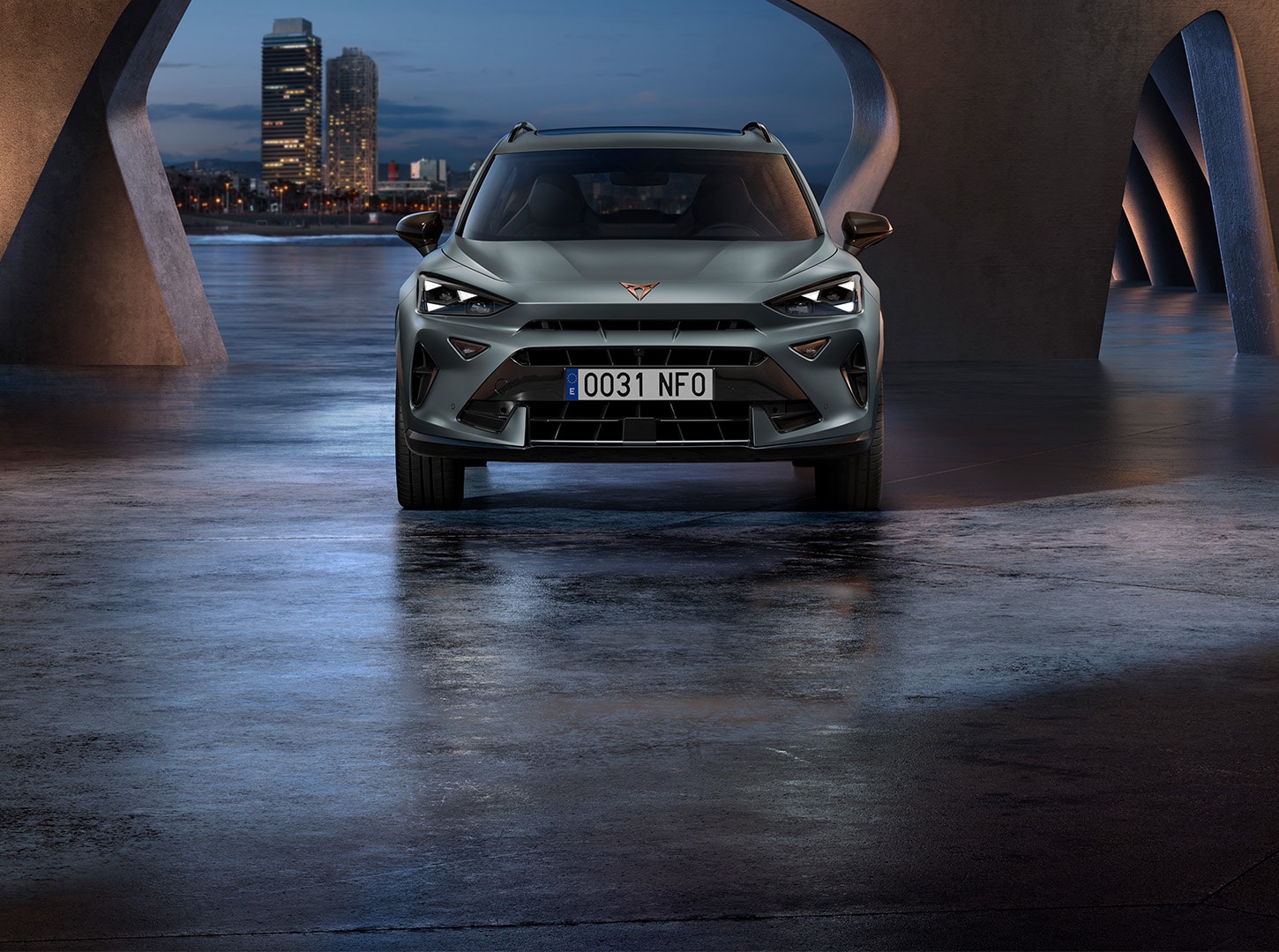 Frontal view of the CUPRA Formentor 2026 parked inside an open building with urban architecture, set against the city backdrop.