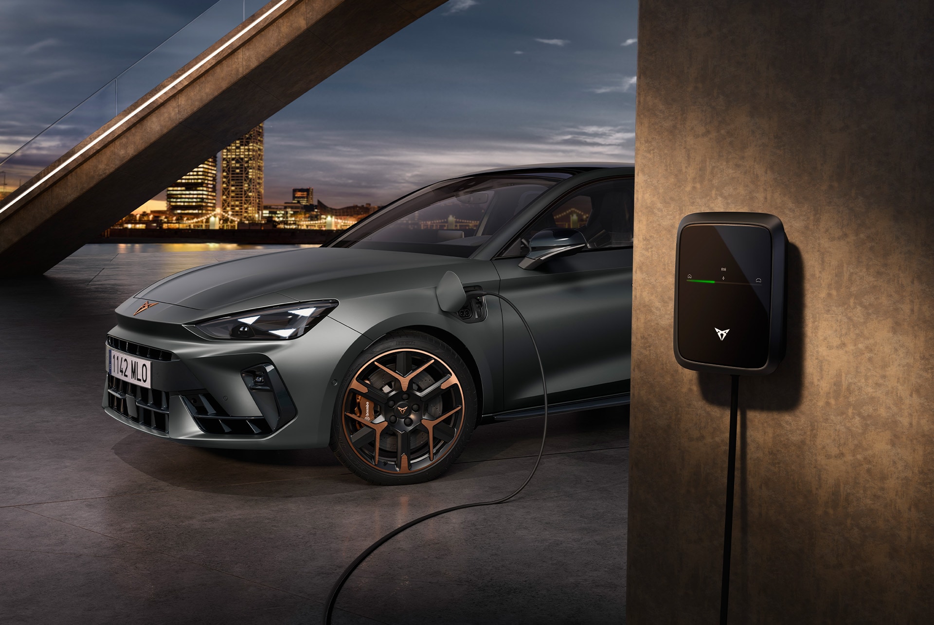 Side, half view shot of the CUPRA Leon Estate VZ e-HYBRID plugged in a urban backdrop.