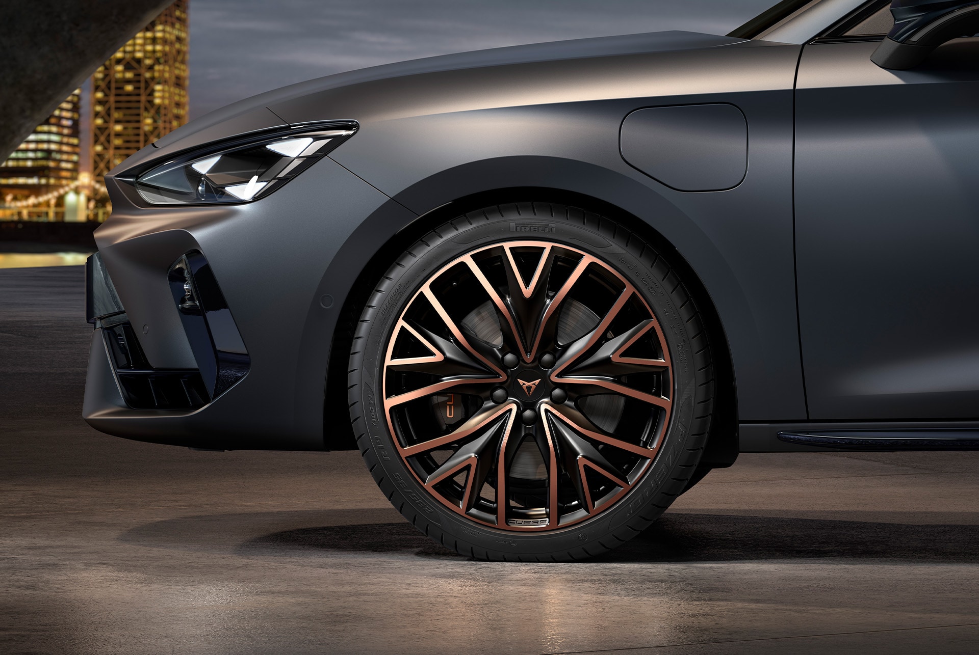 Front side view of left mistral copper forged wheels in copper and black for the CUPRA Leon, tyres, signature headlights and grey body