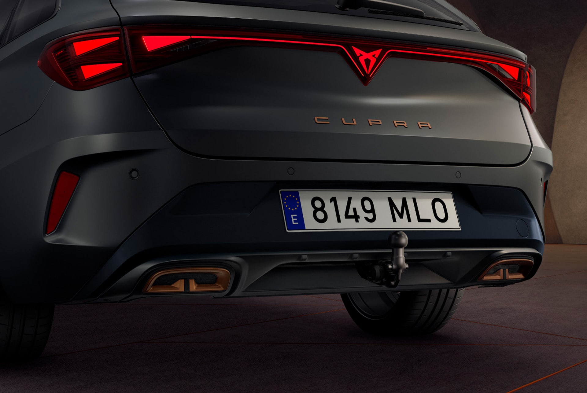 Close up fo rear side view of cupra leon enceladus grey matt hybrid car, copper accent forged wheels, concrete structure and city skyline