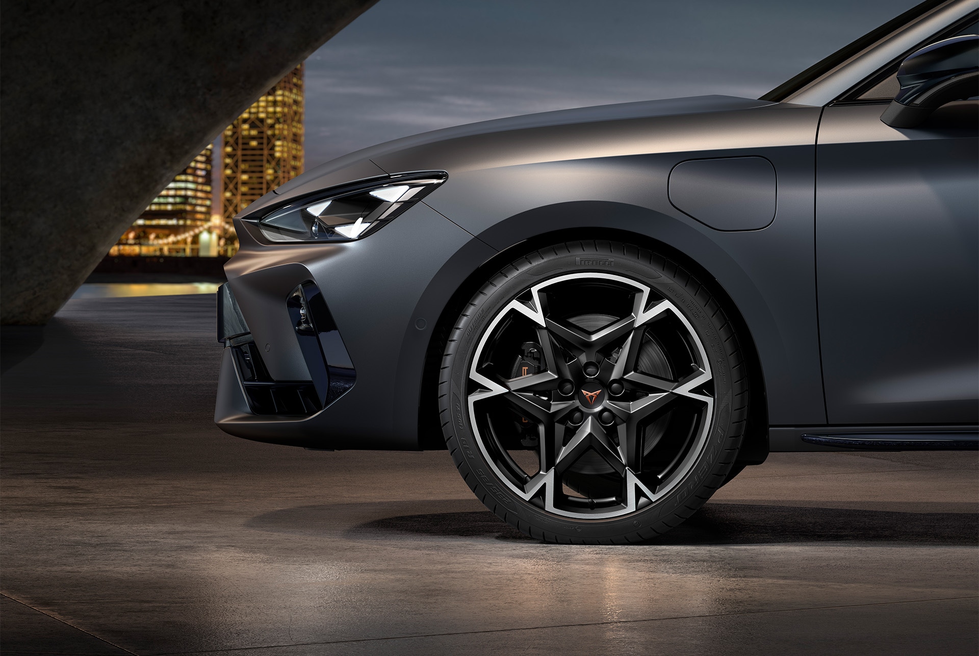 Front side view of left machined polar alloy wheel in black and silver for the CUPRA Leon, tyres, signature headlights and grey body