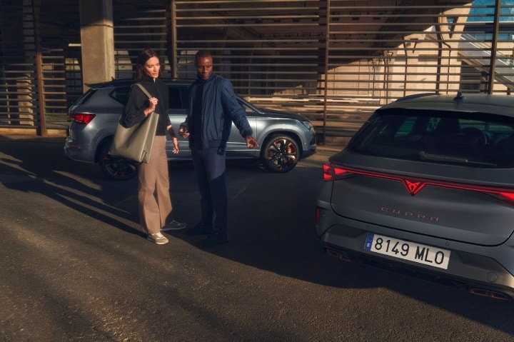 Two people chatting whilst admiring CUPRA vehicles