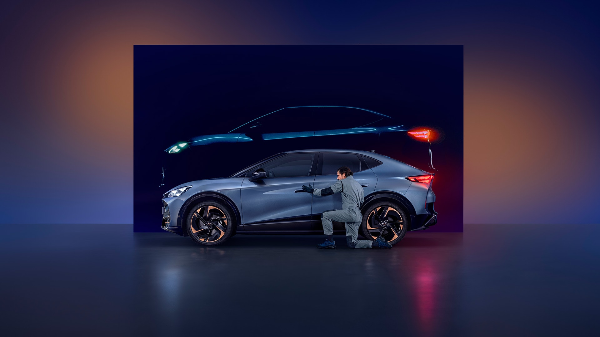 A man wearing overalls inspecting a blue CUPRA Tavascan