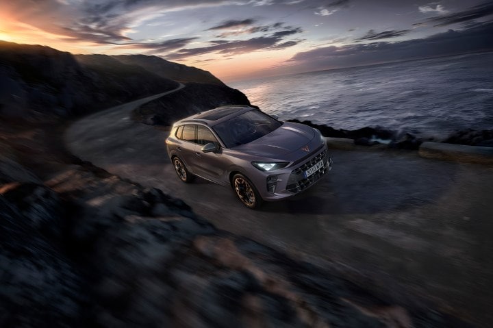 A CUPRA Terramar driving along a mountainous road by the ocean A CUPRA Terramar driving along a mountainous road by the ocean
