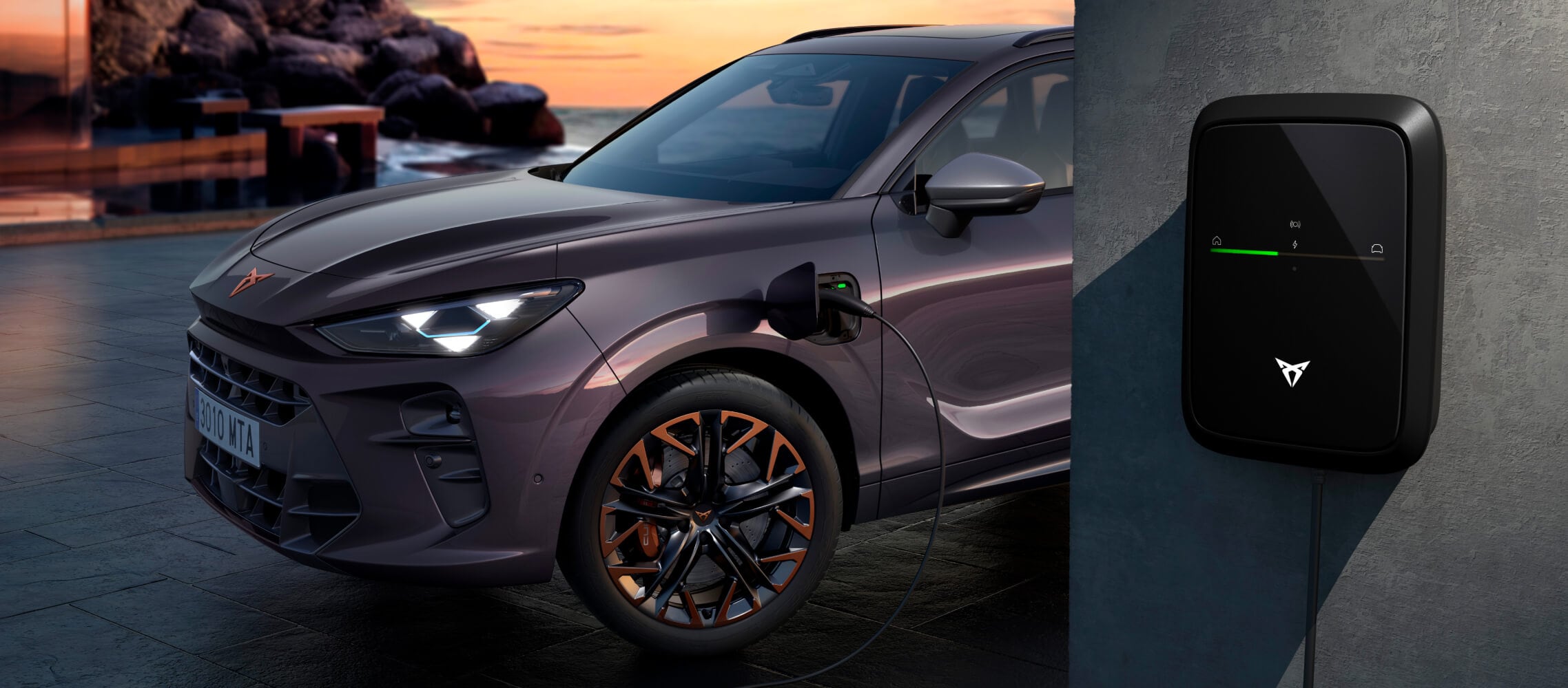 CUPRA Terramar VZ PHEV company car, for CUPRA fleet solutions, in the dark void colour parked while charging with the CUPRA charger, set against a scenic backdrop at sunset.
