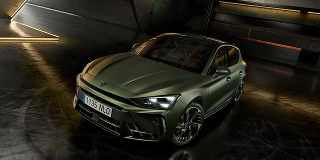 CUPRA Leon, Tribe Edition, in matte green parked in a modern indoor space with ambient lighting and industrial design. CUPRA Leon, Tribe Edition, in matte green parked in a modern indoor space with ambient lighting and industrial design.