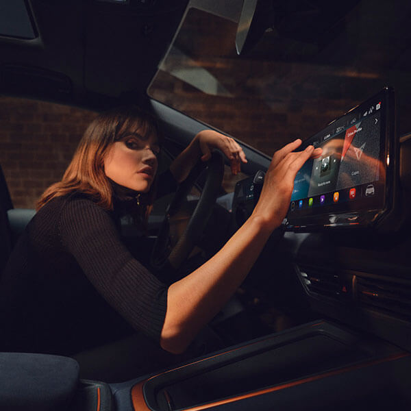 Lady pressing buttons on CUPRA Born infotainment system